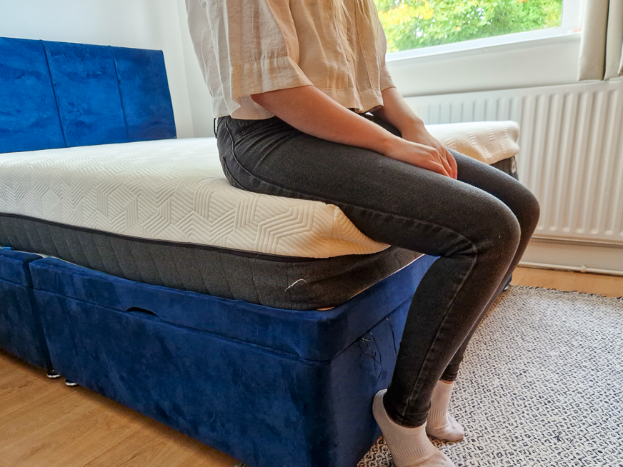 person sitting at edge of mattress